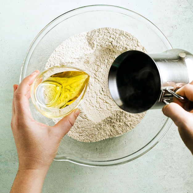 Mixing dough for chocolate cake in a bowl female hands and a kitchen whisk recipe step by step