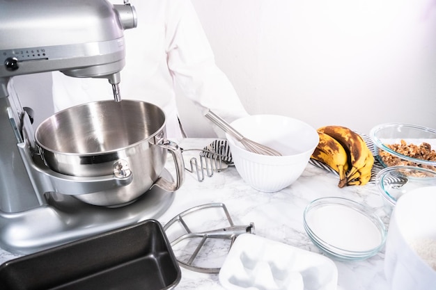 Mixing ingredients in kitchen mixer to bake banana nut bread.