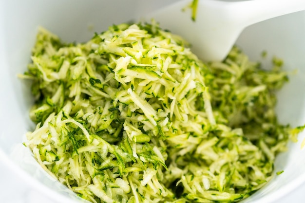 Mixing ingredients in mixing bowl to make zucchini cakes.