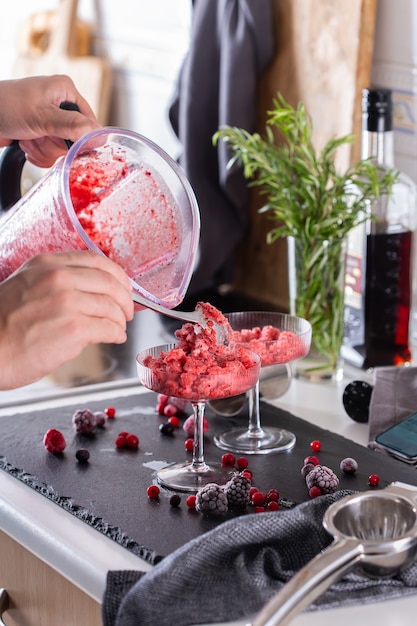 Mixologist making refreshing slushy or slushie cocktail at home