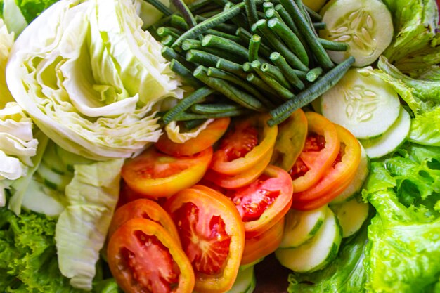 a mixture of healthy salad vegetables fresh cucumbers cabbage tomatoes long beans or Yardlong bean Diet menu Top view flat lay