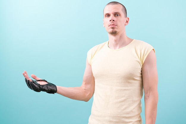 An MMA fighter in black gloves and a yellow shirt show standing on a blue background Fighting Combat Box Knockout Artist Bald Mixed Martial Arts Heavy Good Satisfied