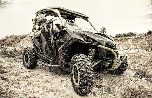 Mobile group of special operations forces, military patrol, quick reaction fighting team moving on light desert vehicle in sandy area. Modern army speed off road vehicle, combat buggy on battlefield