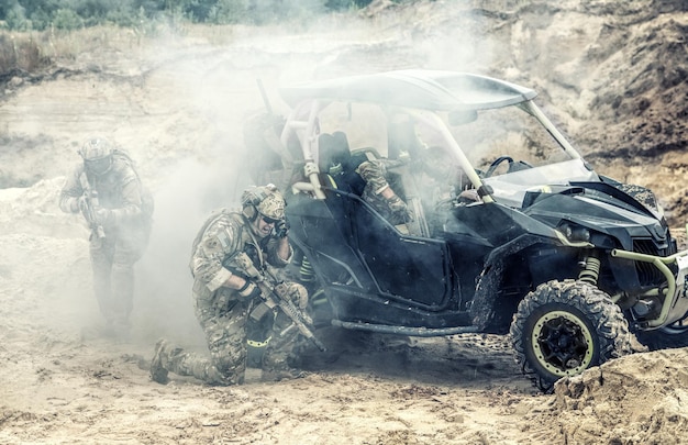 Mobile group of US commandos, special forces team on desert patrol vehicle fighting with enemy, covering position with smoke screen, calling for reinforcements while being under attack in sandy area