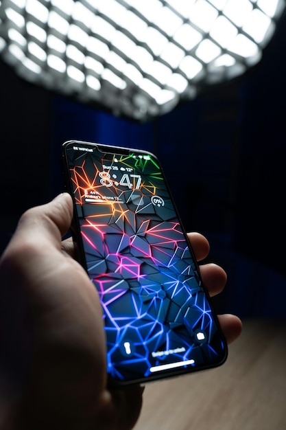 Mobile in hand with colorfull wallpaper