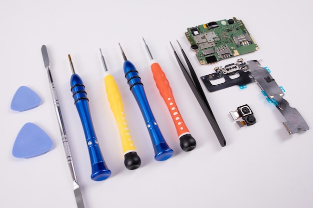 Mobile phone repair tools next to telephone parts