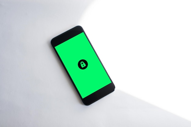 Mobile phone with green screen and padlock symbol. Concept of protection and security.