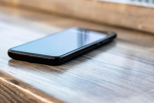 Mobile phone on a wooden table closeup