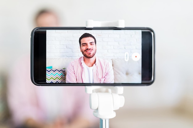 Mobile screen showing the man recording his vlog at home