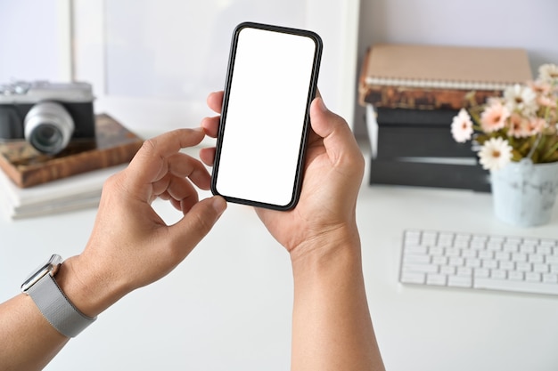 Mobile smart phone in man's hand at desk work.