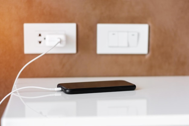 Mobile smartphone charging battery on table at home or office Technology multiple sharing and recharge concepts