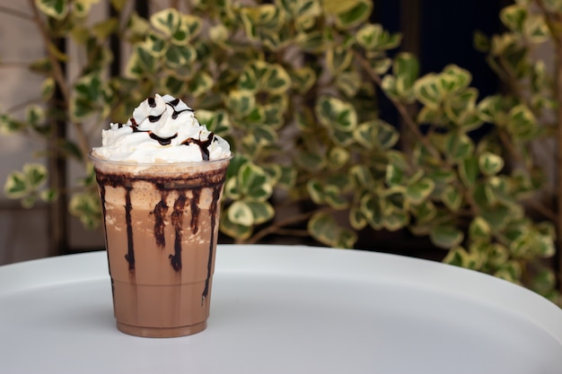 Mocha frappe in plastic cup. Served with whipping cream and chocolate sauce. Freshness drink. Favorite caffeine beverage menu.