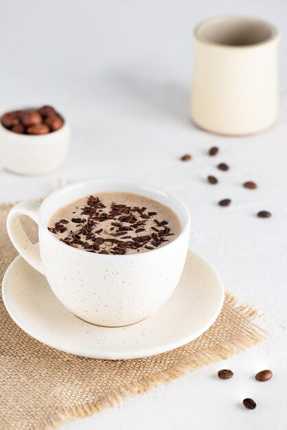 Mochaccino coffee with chocolate and coconut milk in a mug on a light table.