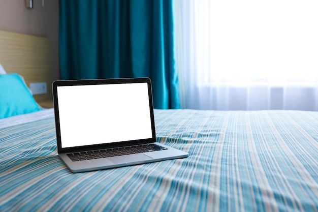 Mock up Blank screen laptop on the bed for advertising and text.