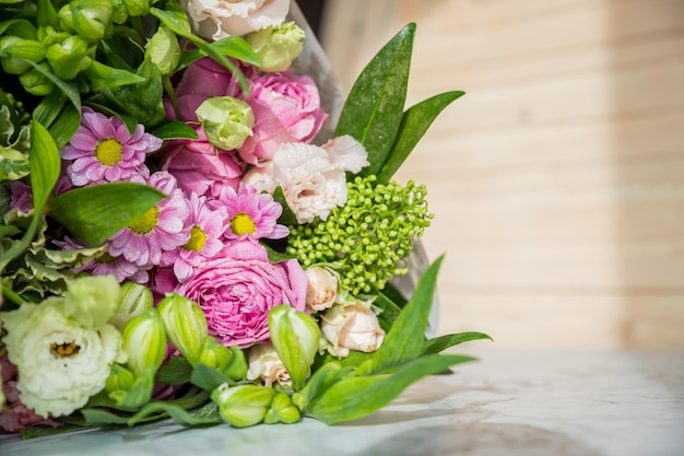 Mock up bouquet of roses daisies lisianthus chrysanthemums unopened buds on tablewhite freesias carn