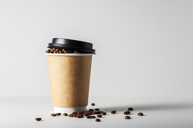 Mock-up of a coffee cup on a gray background with scattered coffee beans.