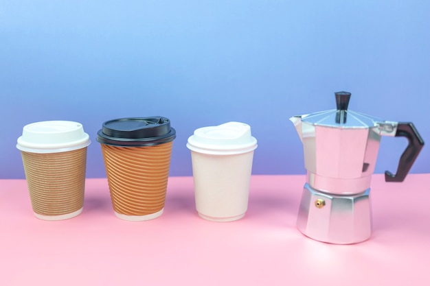 Mock up of coffee paper cups with coffee maker on colorful background.