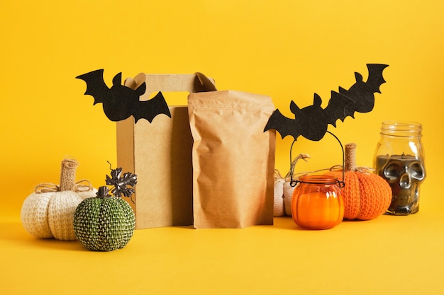 Mock up craft paper or cardboard packaging and halloween decor on a yellow background halloween shopping