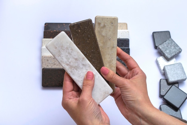 Mock up from natural stones top view closeup Female hands advertises repair materials Floor tiles tiles countertops