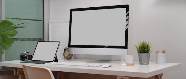 Mock up laptop, computer, camera and decorations on white desk in home office room