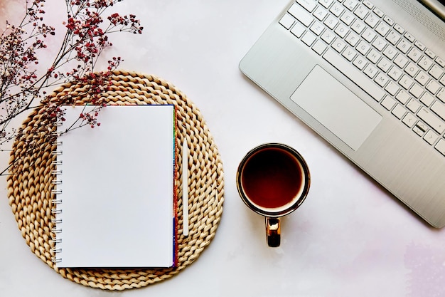 Mock up notepad laptop tea cup and gypsophila flower List of goals to do list concept Cozy home aesthetic Copy space View from above