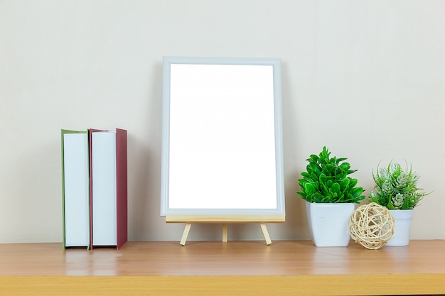 Mock up white picture frame on wood table.