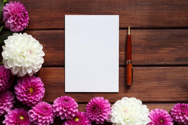 Mock up with blank sheet of paper pompom dahlias and pen Copy space for text  Template for greetings