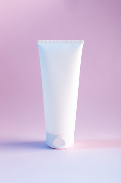 Mock up with whire cream or lotion bottle on a gradient pink background