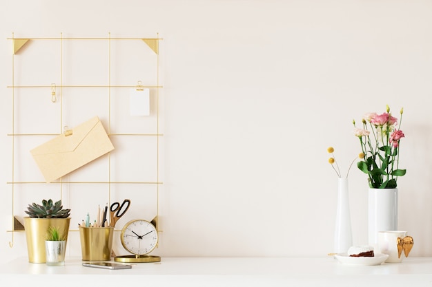 Mock up of woman workplace on light background. Business office desk with golden colors. Modern design. Minimal style.