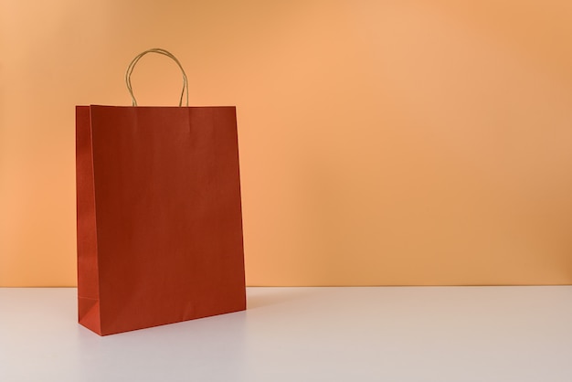 Mockup of blank craft package or colorful paper shopping bag with handles