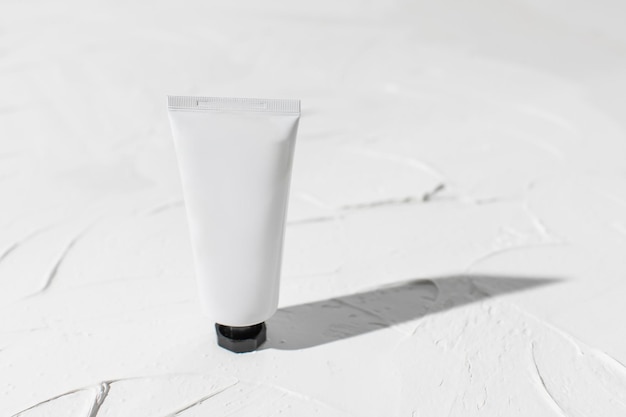 Mockup of blank plastic tube with moisturizer cream facial cleanser standing on white background