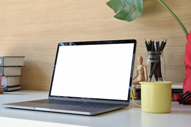 Mockup Blank screen laptop and office supplies on white table.