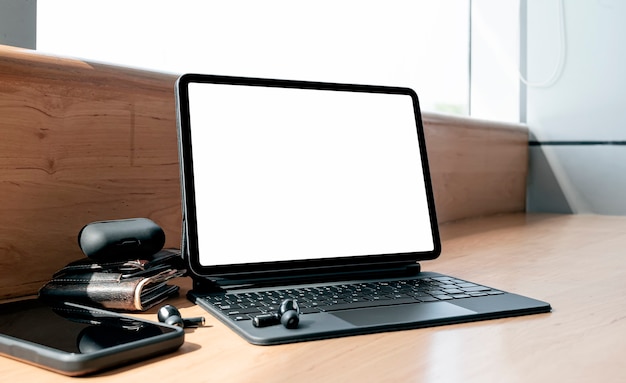 Mockup blank screen tablet with keyboard on wooden counter table in cafe