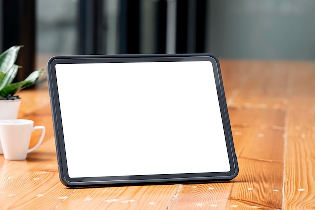 Mockup blank white screen tablet on wooden table, closeup view.