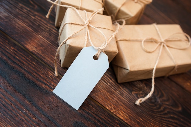 Mockup boxes for gifts of kraft paper and gift tags on a wooden surface