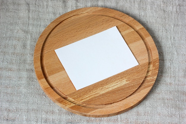 Mockup the creator of the scene a white paper blank card on a cutting board on a gray background