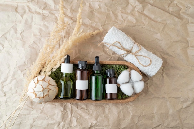 Mockup dropper bottles with face serum or natural oils cotton towel lying on a corky tray