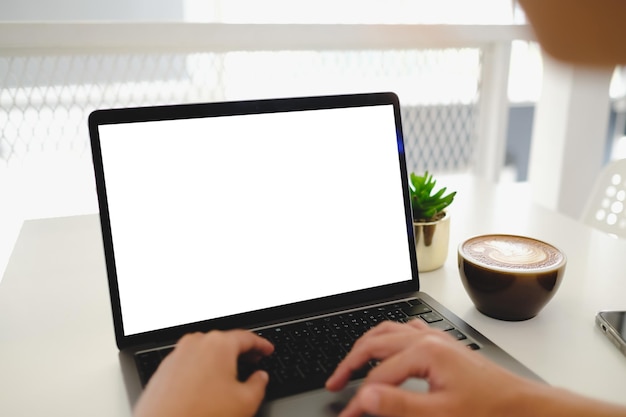 Mockup image computer,cell phone blank screen for hand typing text,using laptop contact business searching information in workplace on desk at office.design creative work space on wooden desk