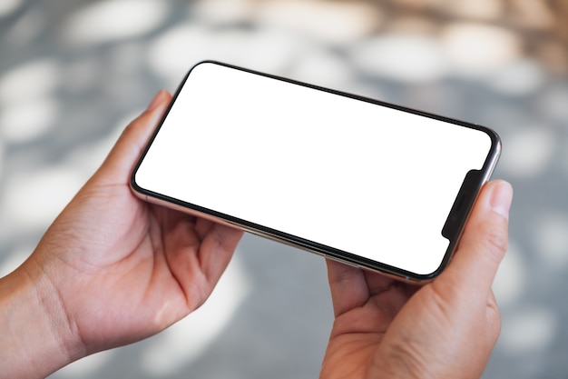 Mockup image of hands holding black mobile phone with blank desktop screen