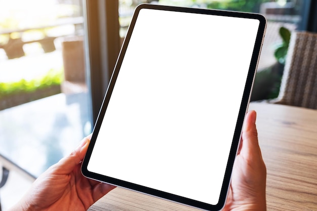 Mockup image of a woman holding black tablet pc with blank white desktop screen