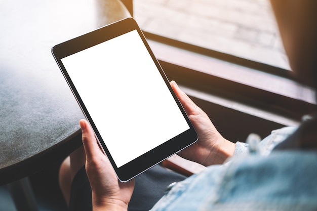 Mockup image of a woman holding black tablet with white blank screen