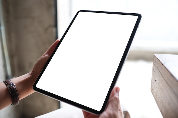 Mockup image of a woman holding digital tablet with blank white desktop screen