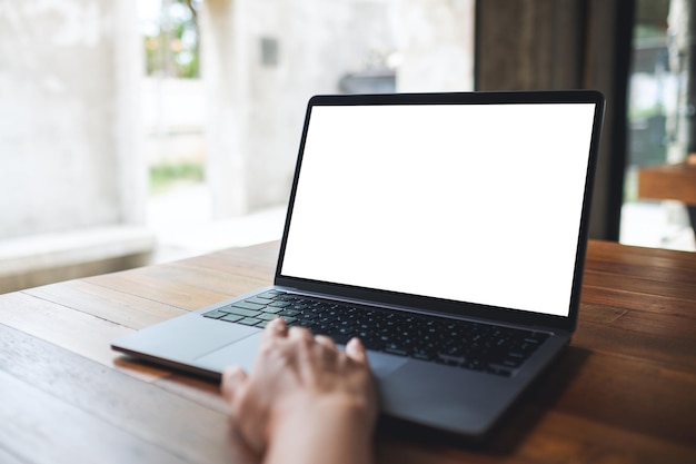 Mockup image of a woman using and touching on laptop touchpad with blank white desktop screen