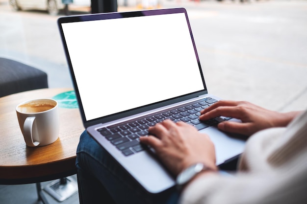 Mockup image of a woman using and typing on laptop computer keyboard with blank white desktop screen