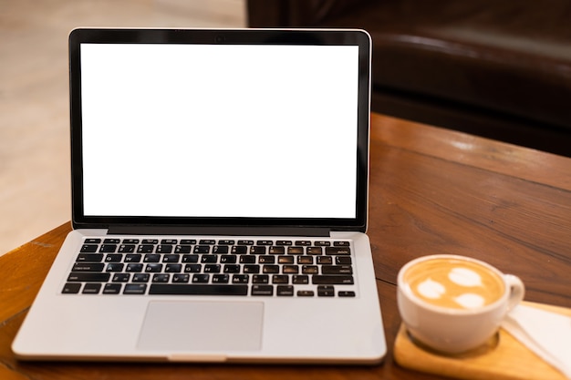 Mockup of laptop computer with empty screen with coffee cup on table of the coffee shop background,White screen