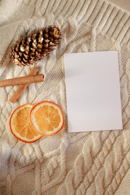 mockup of a sheet of paper on the background of knitted clothes with decorative elements of cinnamon