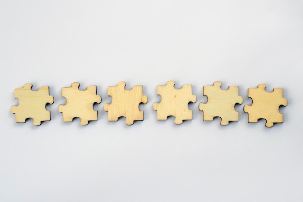 A mockup of six blank wooden puzzles on a white background for your text or design For brainstorming