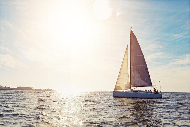 Photo mockup sunset and a yacht at sea for travel tourism or a luxury summer vacation outdoor blue sky water and wave with a boat on the ocean in nature for an adventure holiday or getaway with flare