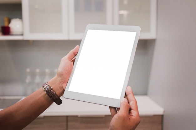 Mockup tablet on businessman hands empty display on home table.