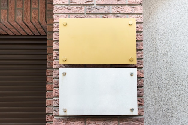 Mockup template with two blank metallic gray and yellow boards on street building facade